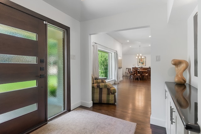 doorway to outside featuring dark hardwood / wood-style floors and an inviting chandelier