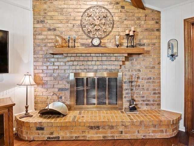 interior details with hardwood / wood-style floors, a brick fireplace, and ornamental molding