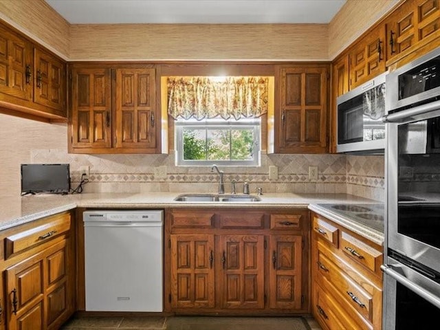 kitchen with tasteful backsplash, sink, and appliances with stainless steel finishes