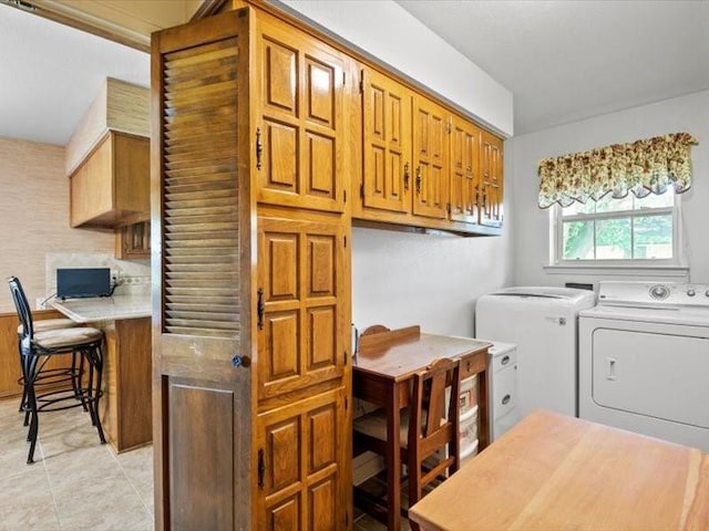 laundry room with light tile patterned flooring, cabinets, and separate washer and dryer