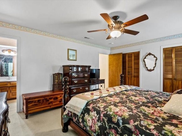 carpeted bedroom with ceiling fan and ensuite bath