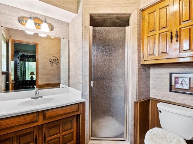 bathroom with toilet, vanity, and walk in shower