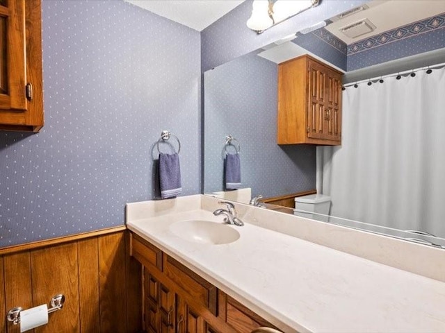 bathroom featuring vanity and wooden walls