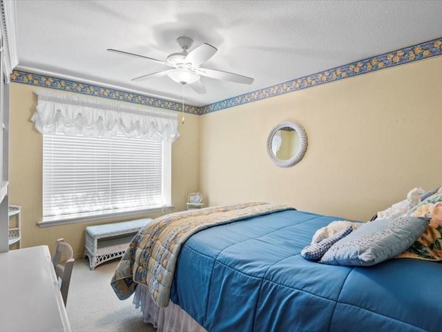 carpeted bedroom with ceiling fan and a textured ceiling