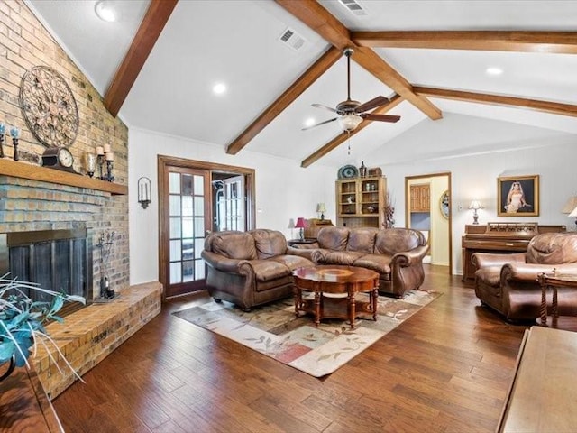 living room with vaulted ceiling with beams, ceiling fan, dark hardwood / wood-style flooring, and a brick fireplace