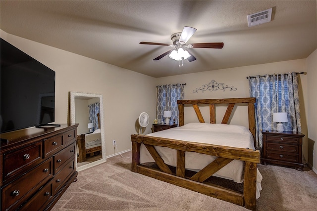 carpeted bedroom with a textured ceiling and ceiling fan