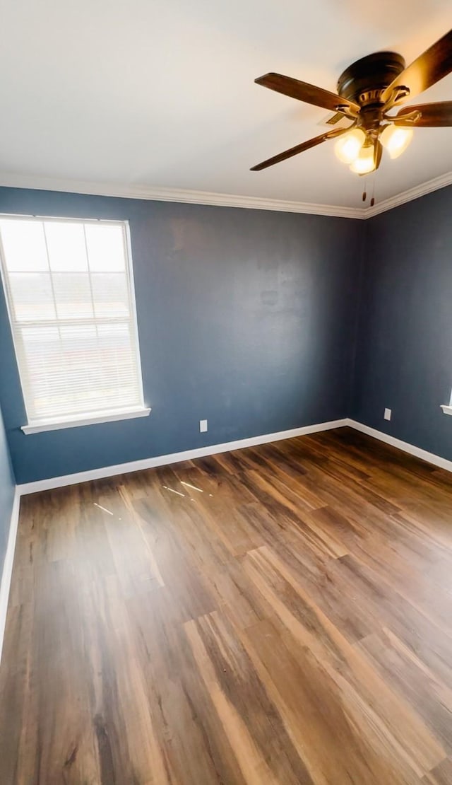 spare room with baseboards, a ceiling fan, wood finished floors, and crown molding