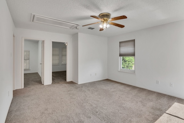 carpeted spare room featuring ceiling fan and a textured ceiling