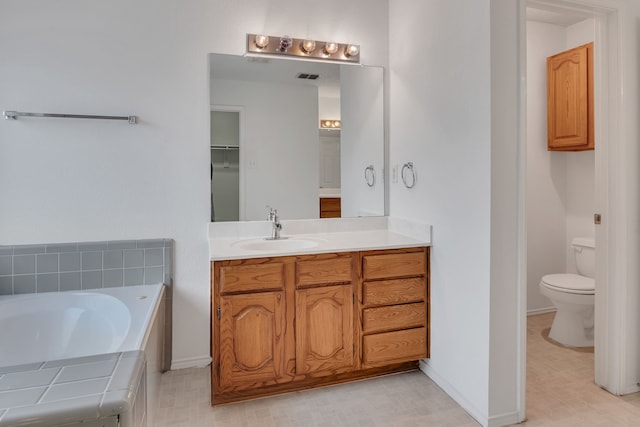 bathroom with a washtub, toilet, and vanity