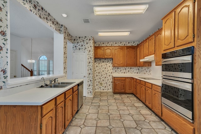 kitchen featuring a textured ceiling, a notable chandelier, sink, and stainless steel appliances