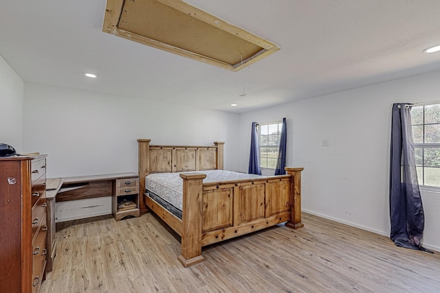 bedroom with light hardwood / wood-style floors and multiple windows