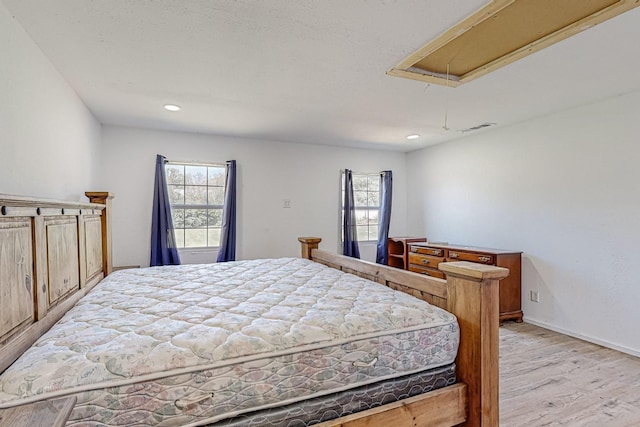 bedroom with light hardwood / wood-style floors and multiple windows