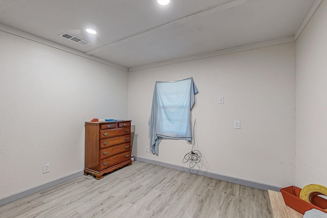 spare room featuring light hardwood / wood-style flooring and crown molding