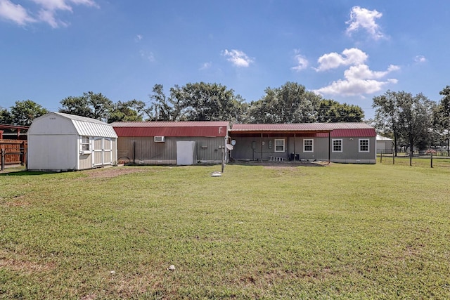 rear view of property with a lawn and a shed