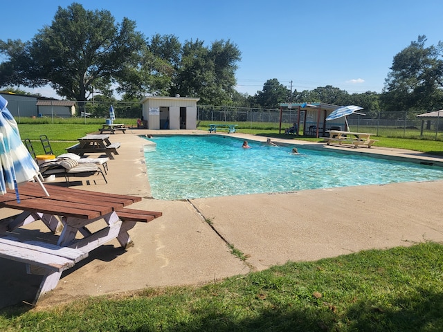 view of pool featuring a storage shed, a patio area, and a yard