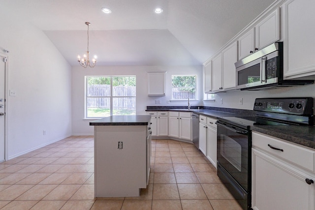 kitchen featuring lofted ceiling, sink, a center island, appliances with stainless steel finishes, and white cabinets