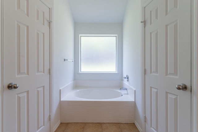 bathroom featuring tiled tub and tile patterned floors