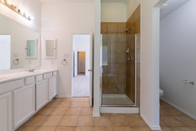 bathroom featuring vanity, tile patterned floors, a shower with door, and toilet