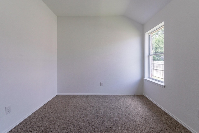 empty room featuring carpet floors and vaulted ceiling