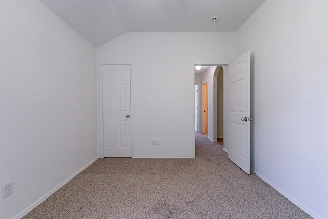 unfurnished bedroom with vaulted ceiling and carpet