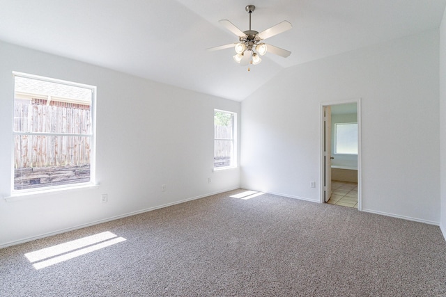 empty room featuring vaulted ceiling, light colored carpet, and ceiling fan