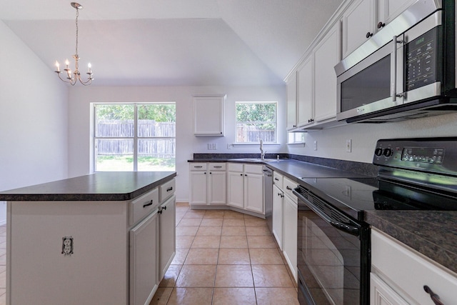 kitchen featuring a kitchen island, lofted ceiling, white cabinets, light tile patterned floors, and stainless steel appliances