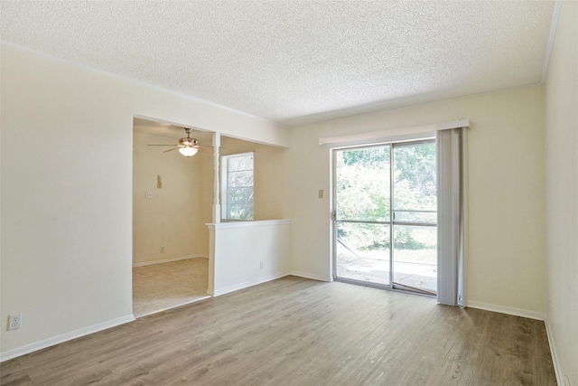 empty room with ceiling fan, light hardwood / wood-style floors, and a textured ceiling