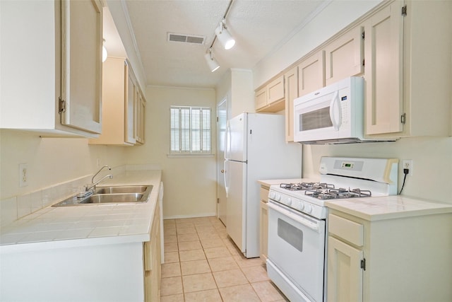 kitchen featuring a textured ceiling, white appliances, crown molding, sink, and light tile patterned floors