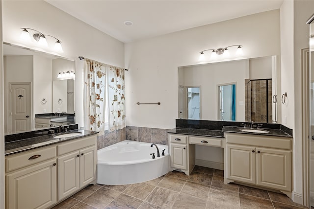 bathroom featuring vanity and independent shower and bath