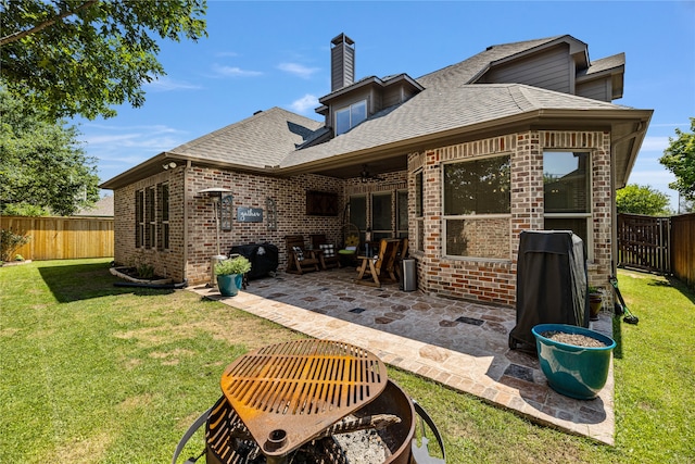 back of property with a yard, a patio, and ceiling fan