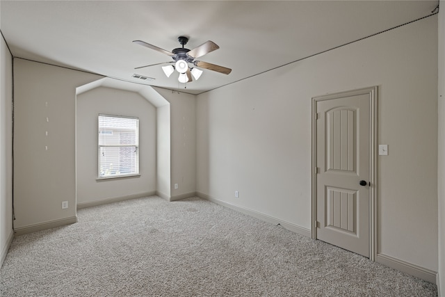 empty room with light carpet, ceiling fan, and vaulted ceiling