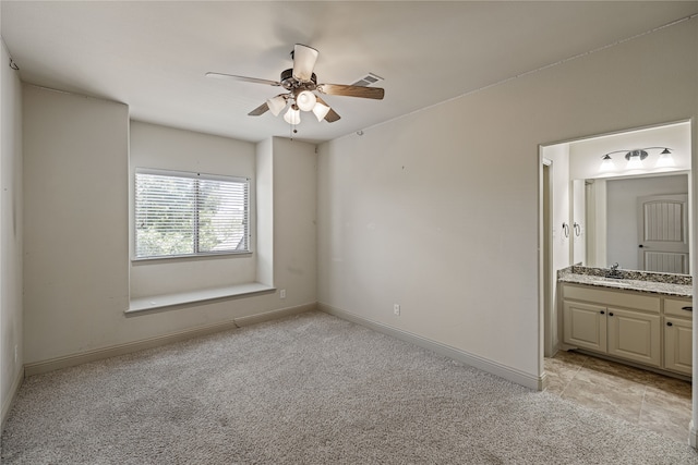 spare room with ceiling fan, sink, and light carpet