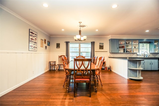 dining room with dark hardwood / wood-style flooring, crown molding, and a notable chandelier