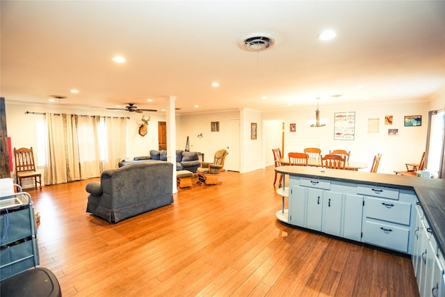 kitchen with ceiling fan, wood-type flooring, crown molding, and blue cabinets