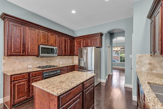 kitchen with a healthy amount of sunlight, dark hardwood / wood-style flooring, kitchen peninsula, and stainless steel appliances