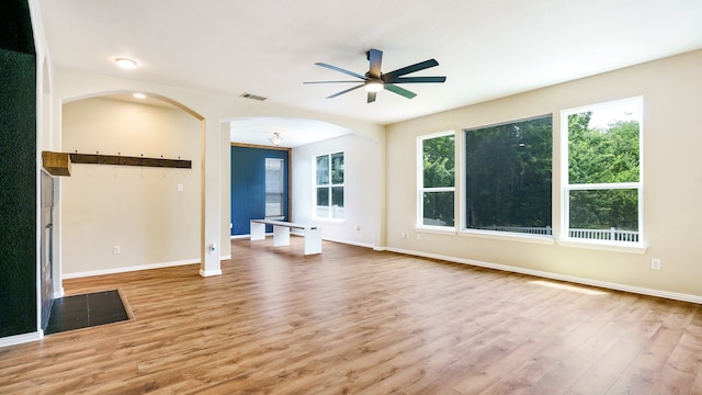 unfurnished living room with wood-type flooring and ceiling fan