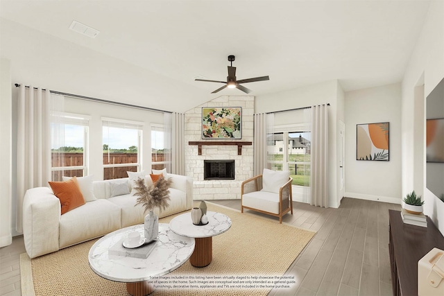 living room featuring vaulted ceiling, ceiling fan, hardwood / wood-style floors, and a stone fireplace