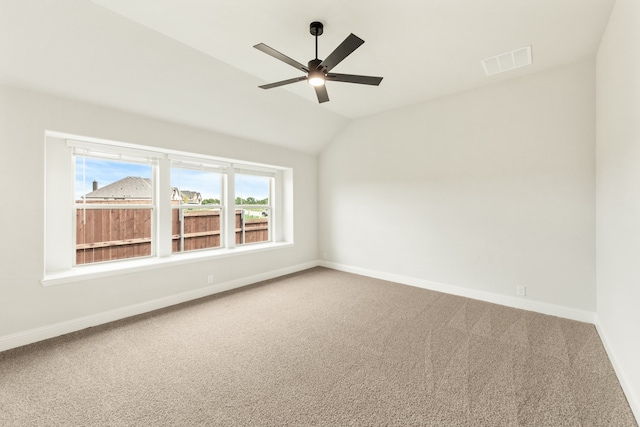 empty room with lofted ceiling, carpet flooring, and ceiling fan