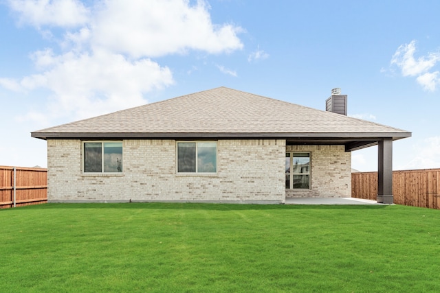 rear view of property with a lawn and a patio