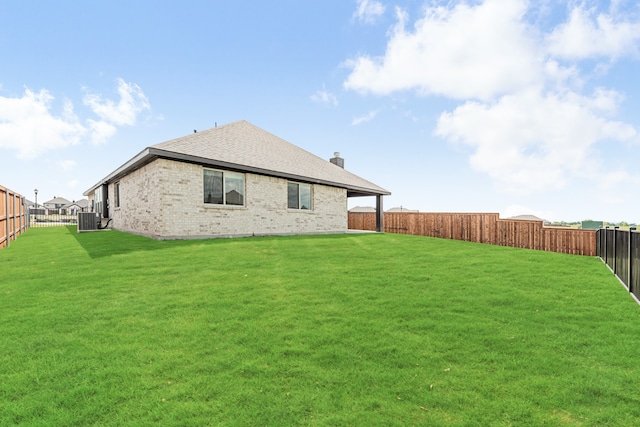 back of house with cooling unit and a yard