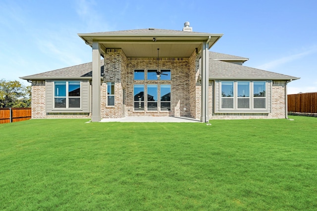 back of house with a lawn, a patio area, brick siding, a fenced backyard, and a shingled roof