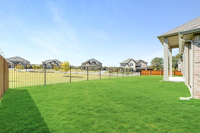 view of yard with a fenced backyard and a residential view