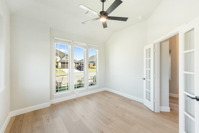 unfurnished room featuring french doors, a ceiling fan, vaulted ceiling, light wood-type flooring, and baseboards