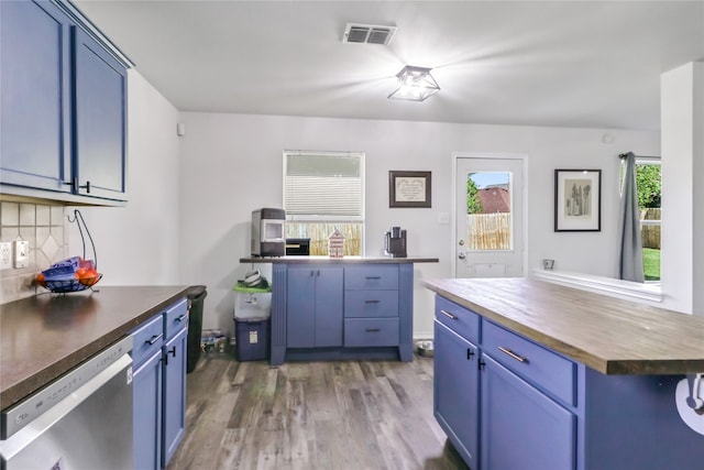 kitchen with blue cabinets, butcher block countertops, dark hardwood / wood-style flooring, a center island, and stainless steel dishwasher