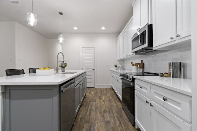 kitchen featuring sink, dark wood-type flooring, stainless steel appliances, a kitchen island with sink, and white cabinets