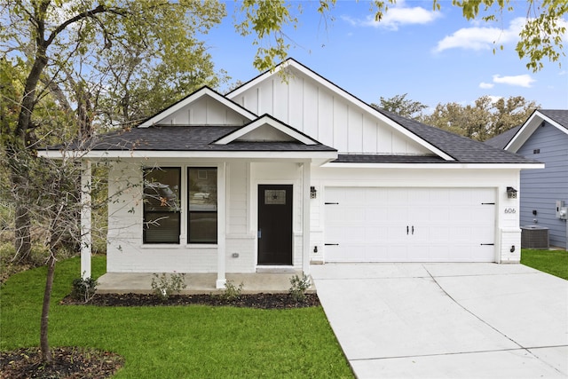 view of front of property featuring cooling unit, a garage, and a front yard