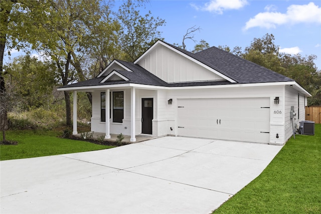 view of front facade featuring central AC, a porch, a front yard, and a garage