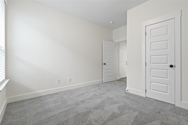 unfurnished bedroom with light carpet and a closet