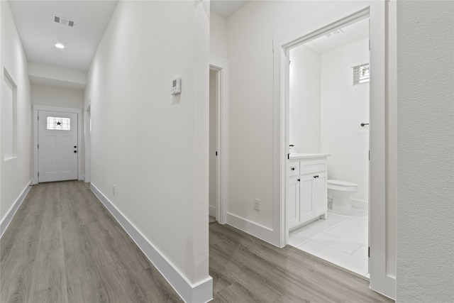 corridor with light hardwood / wood-style floors