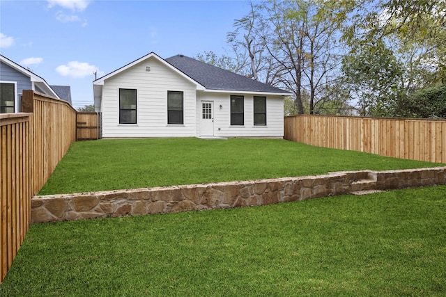 rear view of house featuring a yard